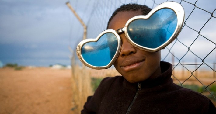 Eine Flüchtlingskind mit selbstgebastelter Herzbrille im Camp Osire, Angola. Eine Flüchtlingskind mit selbstgebastelter Herzbrille im Camp Osire, Angola._©UNHCR / Brandon Bannon